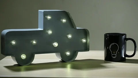 Car lamp led light tea mug bulb symbol nobody wooden table hd footage Stock Footage 105128679