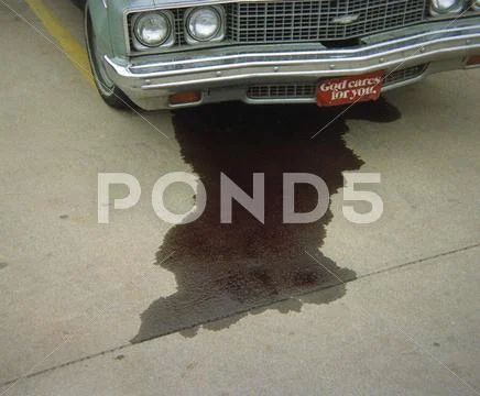 A Car Leaking Fluid Onto The Pavement