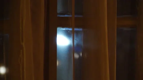 Car light illuminating window during night time. Concept of terror or Stock Footage 134537664