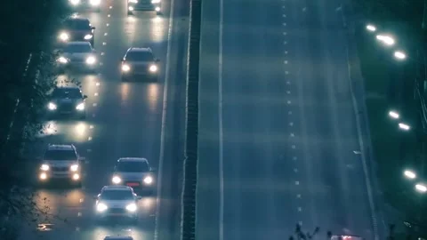 Car lights and side lights in night traffic on one lane of highway going uphill Stock Footage 313159395