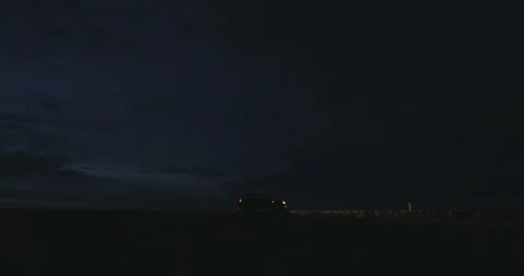 Car with lights on parked at a distance Stock-Footage 103807314