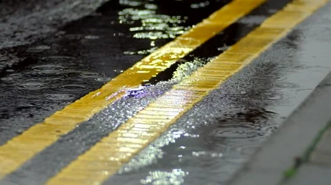 Car lights reflecting in puddles on road during rain Video stock 44013867