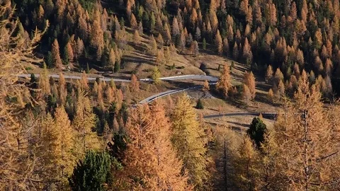 A car on a loopback road in the autumn mountains Stock Footage 80768854