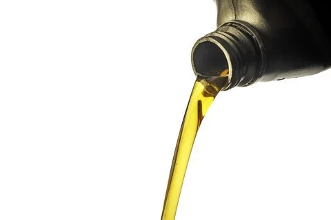Car lubricant flows from gray bottle on isolated white background. Stock Photos
