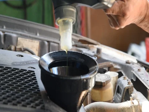 Car maintenance servicing mechanic pouring new oil lubricant into the car engine Stock Footage 77633392