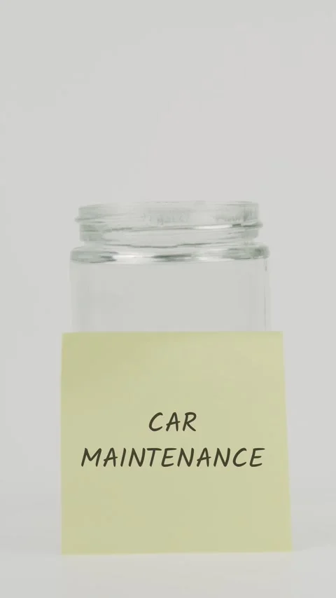 Car maintenance text or word on yellow sticky note attached to glass jar Stock Footage 311688230