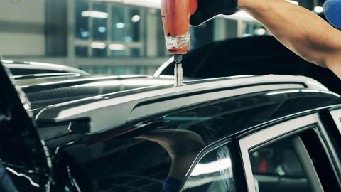 Car manufacturing worker assembling a car roof. Close up Stock Footage 140979058