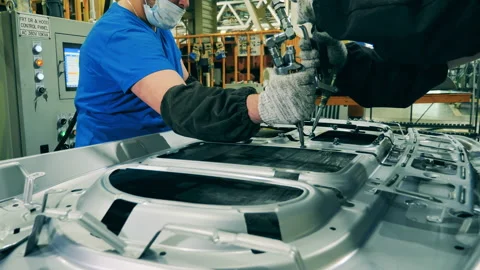 Car manufacturing workers using structural adhesive at a car factory Stock Footage 143242337