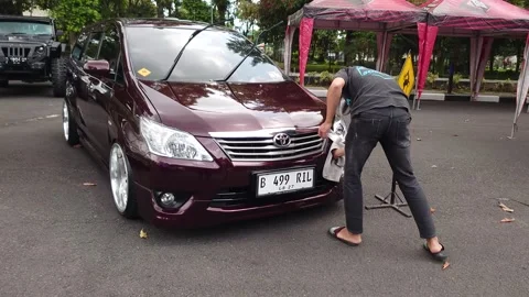 Car; the maroon color is being cleaned manually 스톡 동영상 290100771