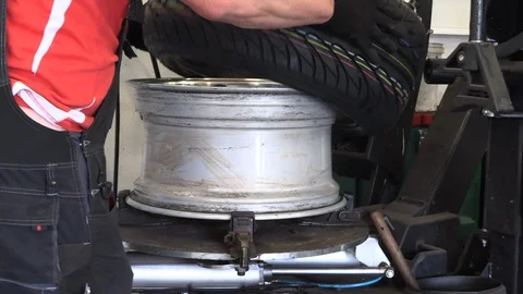 Car mechanic assembles car tires 库存影片 91999265