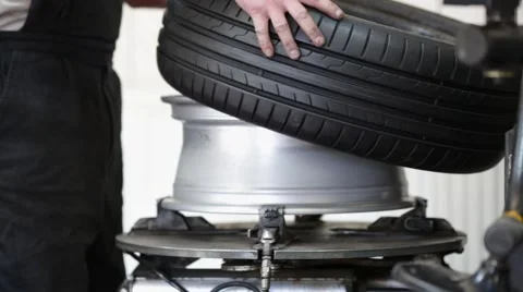 Car mechanic assembling tire on wheel Stock Footage 54234345