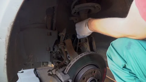 Car mechanic changes shock absorber of car in service station Stock Footage 118252755