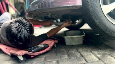 Car Mechanic Changing Engine Oil in Workshop Stock Footage 337924108