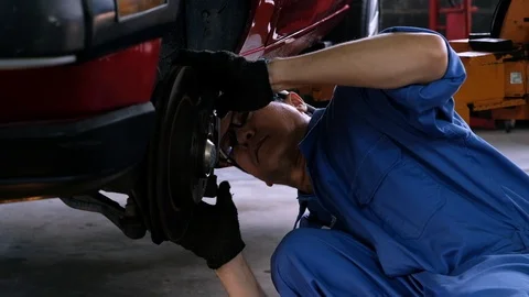 Car mechanic checking brake disc at automobile garage. Stock Footage 122266805