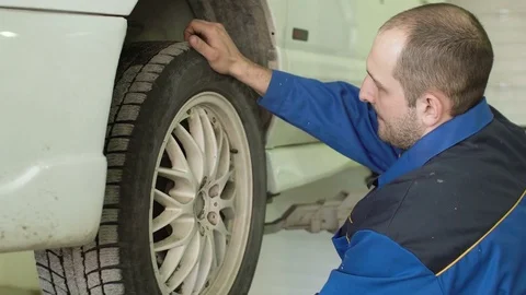 Car mechanic is checking car wheels on crossover in car repair service Stock Footage 74869992