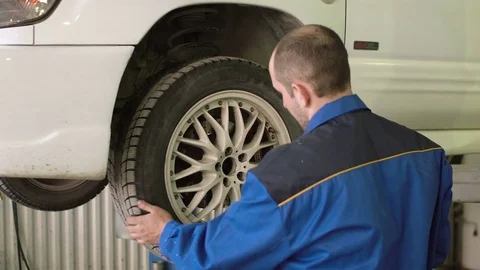 Car mechanic is checking car wheels on crossover in car repair service Video stock 74884461