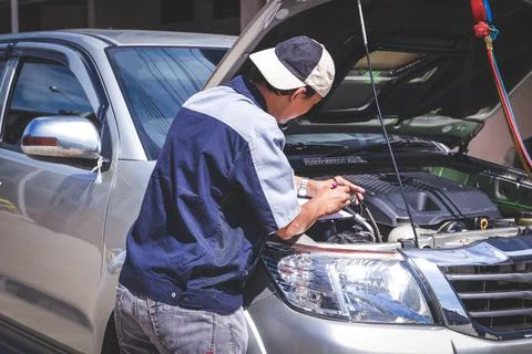 The car mechanic is checking the engine system. 库存照片