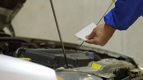 Car mechanic checking oil level in a mechanical at workshop Vidéo 297775791