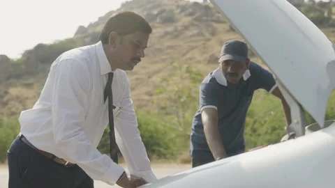 Car mechanic explaining about problem to client about breakdown of vehicle on ro Stock Footage 172065884