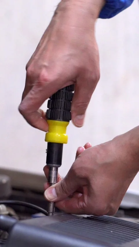 Car mechanic hands and screwdriver tools working on automobile performance. 库存影片 337033770