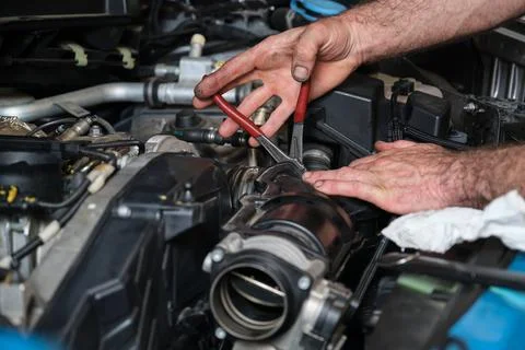 Car mechanic hands replacing engine throttle body. Foto stock