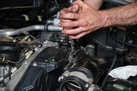 Car mechanic hands replacing engine throttle body. Foto stock