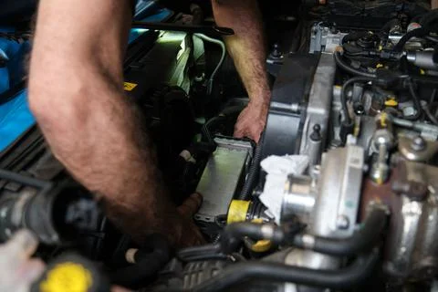 Car mechanic hands replacing intercooler on a car engine. Stock Photos