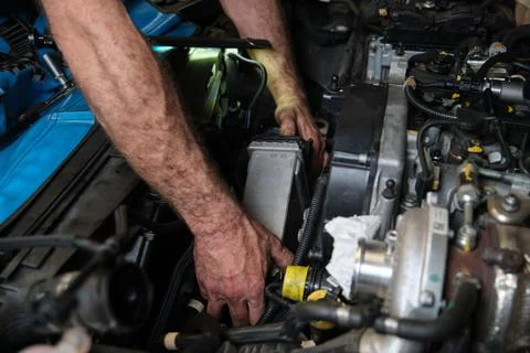 Car mechanic hands replacing intercooler on a car engine. Foto stock