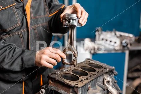 Car mechanic holding a new piston for the engine, overhaul.. Engine on a repair Stock Photos