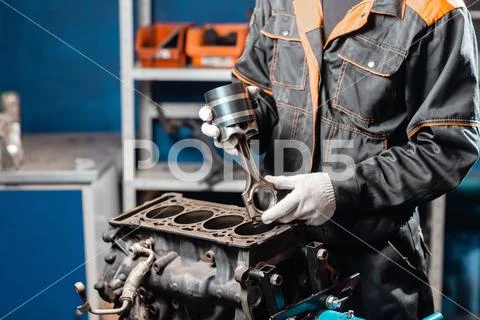 Car mechanic holding a new piston for the engine, overhaul.. Engine on a repair Stock Photos