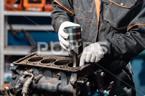 Car mechanic holding a new piston for the engine, overhaul.. Engine on a repair Stock Photos