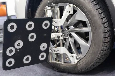 Car mechanic installing sensor during suspension adjustment and automobile Stock Photos