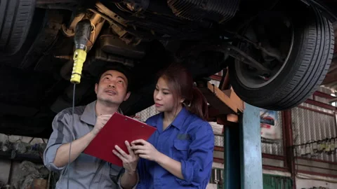 The car mechanic or Couple engineer stand and surveying engine. Stock Footage 177937576