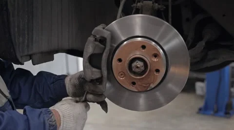 Car mechanic Repairing brakes on car in modern service workshop Stock Footage