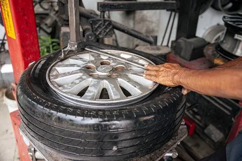 Car mechanic repairs punctured tire Foto stock