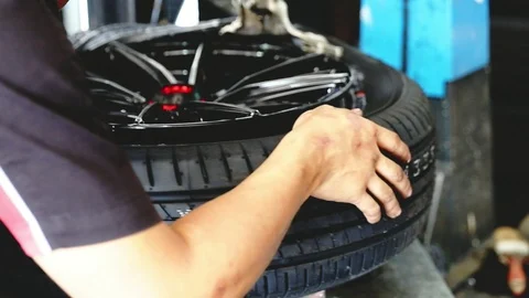 Car mechanic replace tire on wheel in auto repair service. Stock Footage 107092333