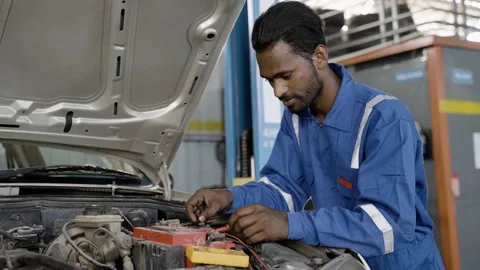 Car mechanic testing or checking car engine battery by using digital multimeter  Stock Footage 171815923