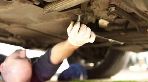 Car mechanic unscrewing a component under the car Stock-Footage 36212272