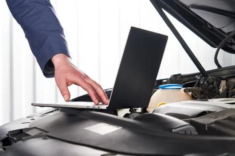 Car mechanic using computer in auto repair shop Stock Photos