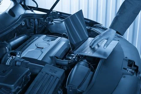 Car mechanic using computer in auto repair shop Stock Photos