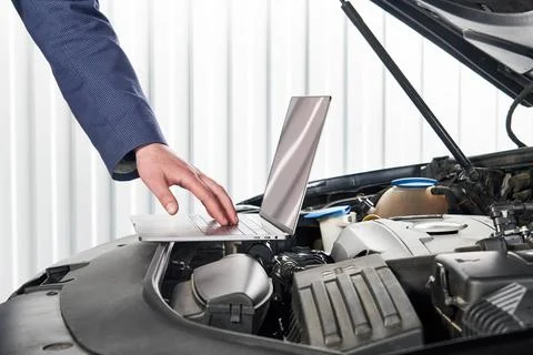 Car mechanic using computer in auto repair shop Services car engine machin... Stock Photos