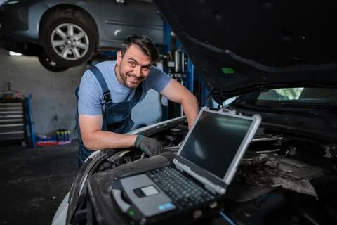 Car mechanic using a computer to diagnose a car engine problem Stock Photos