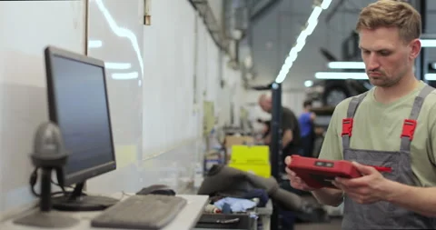 Car mechanic using computer to run diagnostic software Stock Footage 341870900
