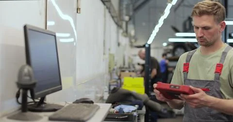 Car mechanic using computer to run diagnostic software for troubleshooting .. Stock Photos