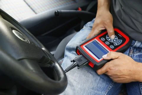 Car mechanic using an electronic device Stock Photos