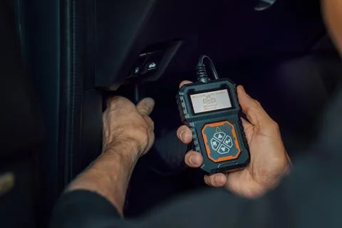 Car mechanic using OBD2 scanner, code reader tool to check engine errors an.. Stock Photos