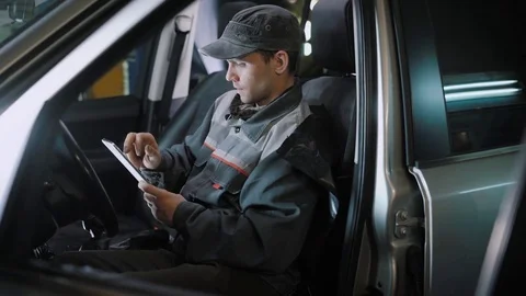 Car mechanic using tablet in car Stock Footage 84311080