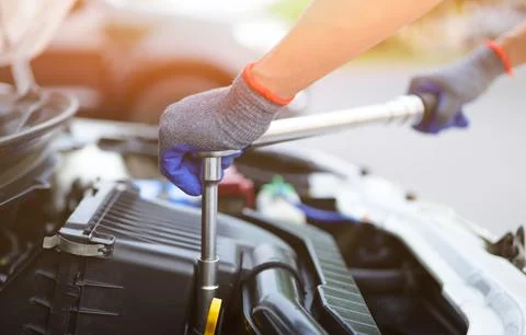 Car mechanic using the torque wrench to repairing in car engine room. Stock Photos
