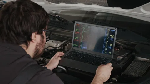 Car Mechanic Watching Engine Performance Graphs during Computer Diagnostics Stock Footage 329408720