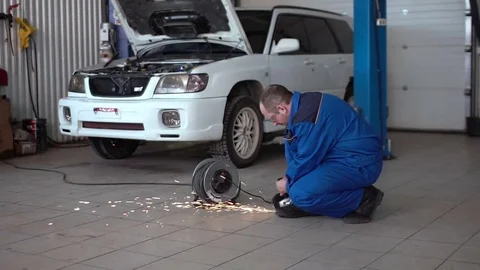 Car mechanic work with circular saw cutting metal with sparks in super slow Stock Footage 74908182